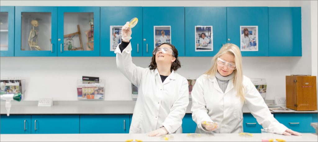 A student holding up a science dish in a laboratory