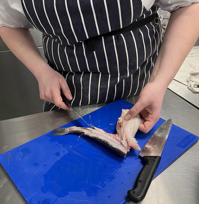 A Professional Cookery student at Harrogate College preparing fish
