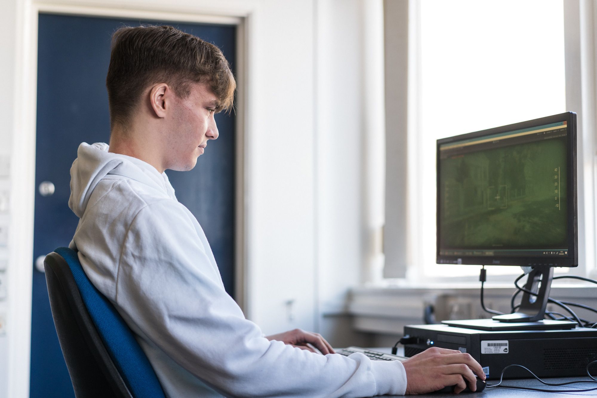 Male student on an esports course at HC sitting at a computer playing a game
