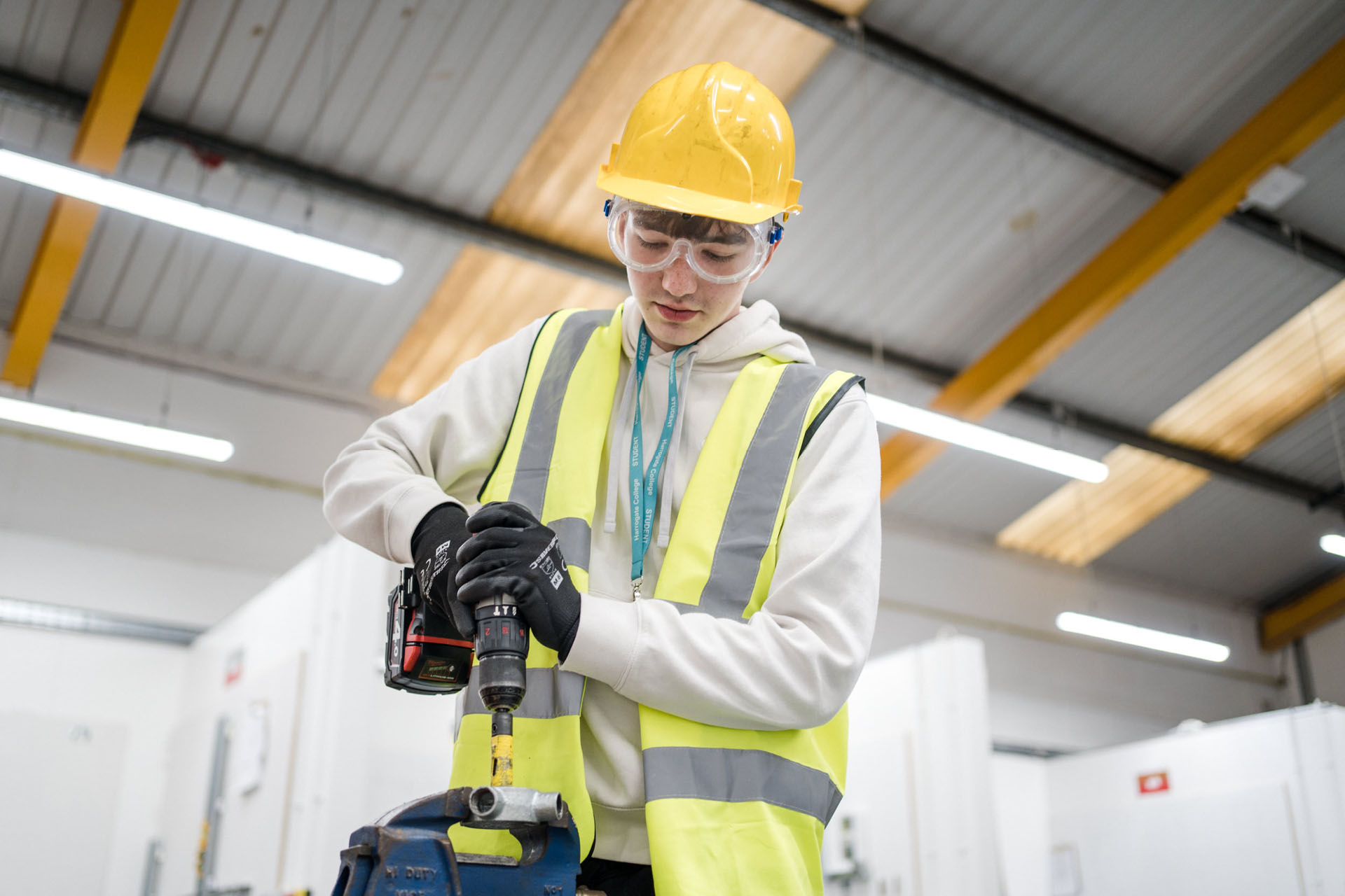 Harrogate College construction student drilling in to a wooden frame wearing protective clothing while doing so