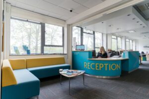 Harrogate College reception area with a member of staff working on reception