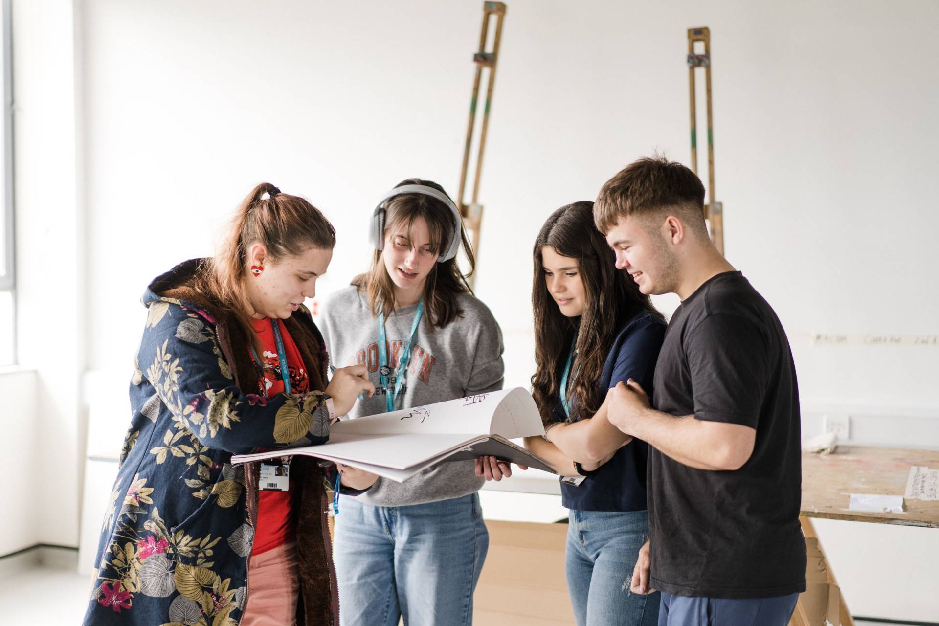 A group of art and design students looking through a sketch book