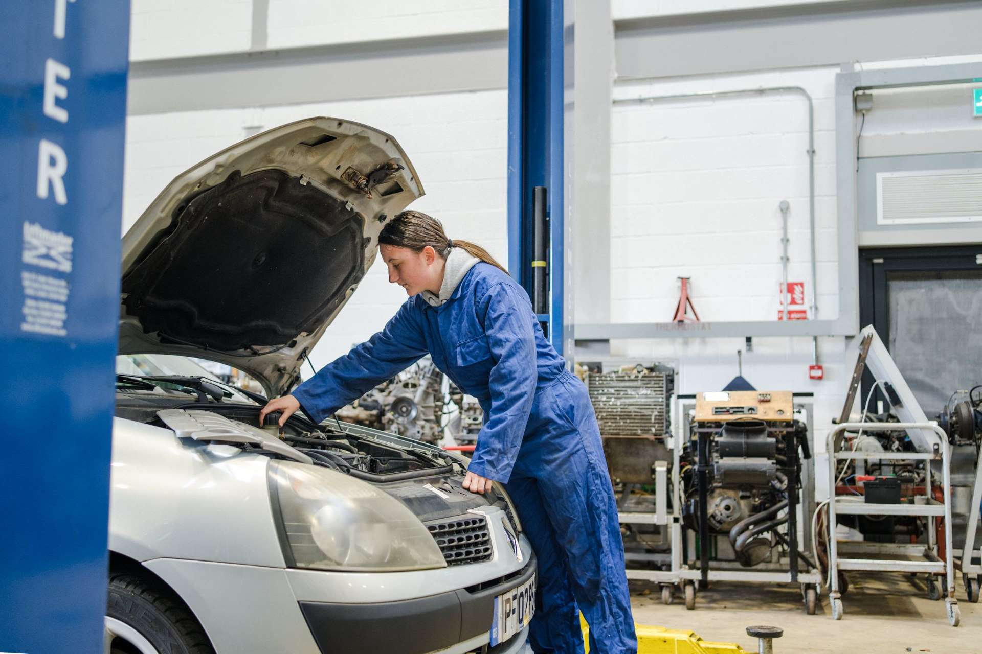 Harrogate College student checking the engine bay of a car