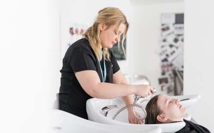 Student washing a client's hair in the hairdressing salon at Harrogate College