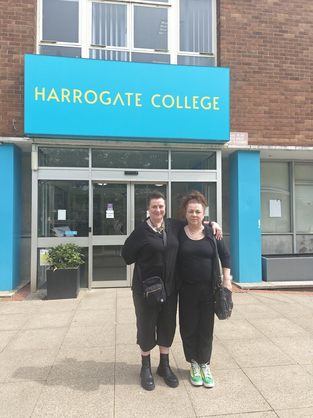 Former Art and Design foundation degree learners standing in front of Harrogate College main entrance