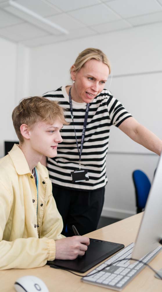 Harrogate College teacher and student both looking at a desktop computer screen together