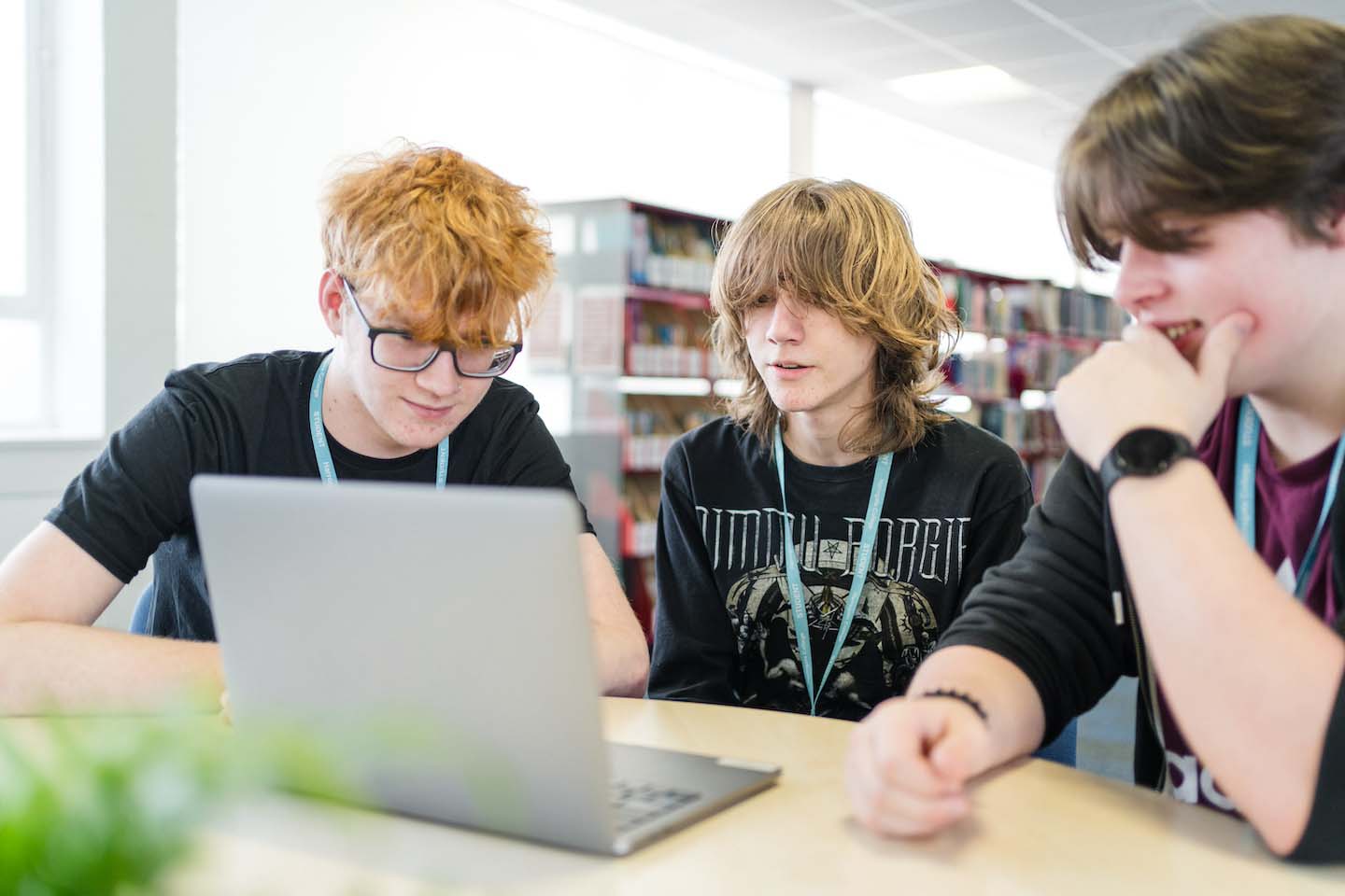 Three Harrogate College students sat down in library looking at a laptop screen together
