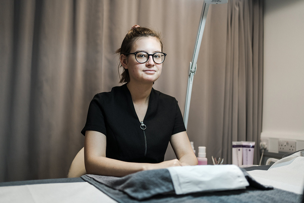 Student sat in the beauty salon in Harrogate College next to the massage equipment