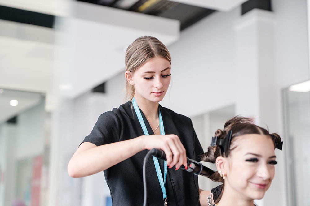 Student curling someone's hair in the hair salon at Harrogate College