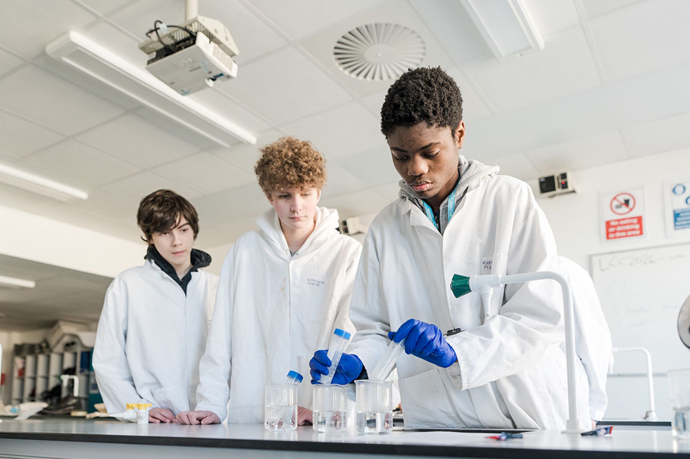 Three students in the science lab at Harrogate College carrying out an experiment with test tubes