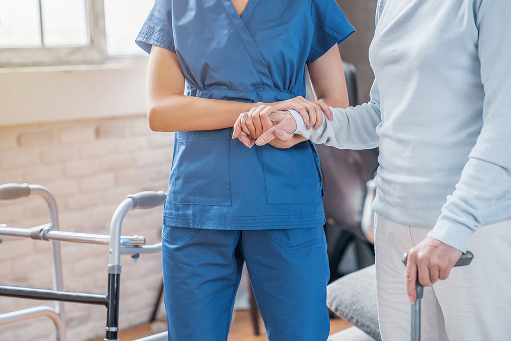 Nurse helping an elderly woman walk