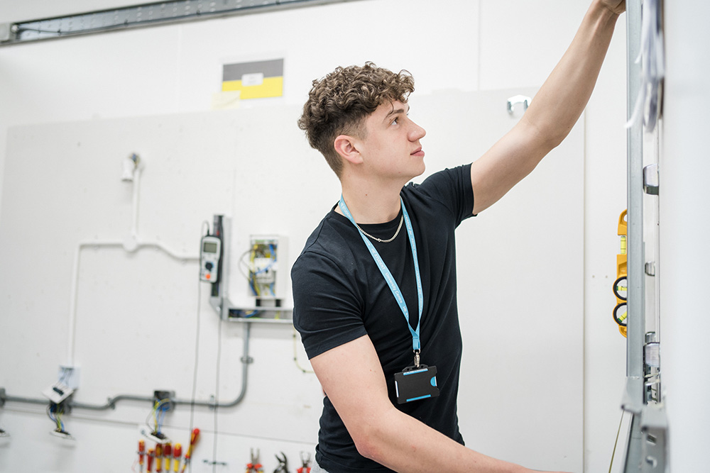 Student looking at the wiring in the wall of the electrical workshop at Harrogate College
