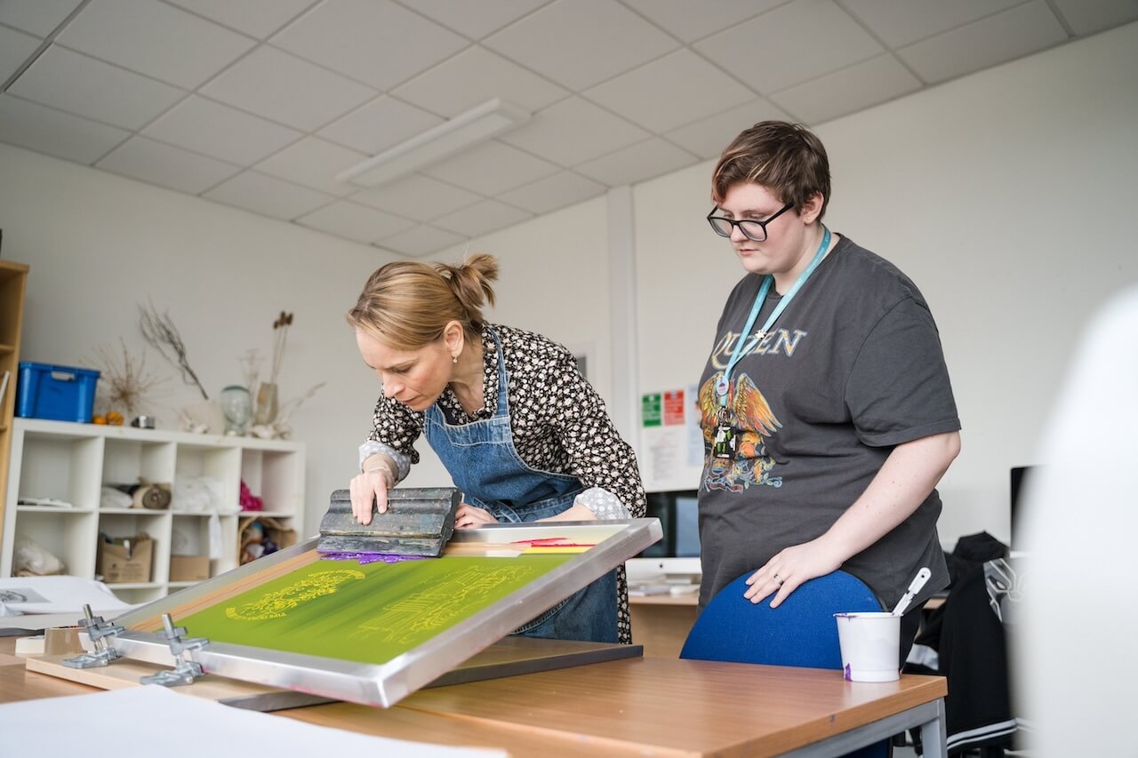 Two students working on a print machine